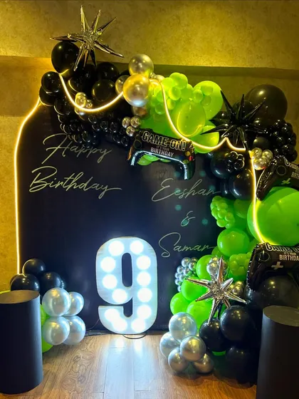 A slightly different perspective of the gaming party setup, capturing the star-shaped metallic balloons and controller-shaped foil balloons within the arch. These details add an extra layer of thematic fun to the decor.