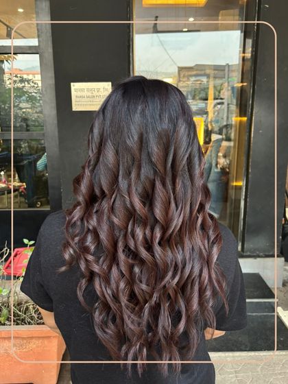 Deep, dark hair gets a touch of dimension with subtle chocolate brown curls. This is a great way to enhance your natural colour with a hint of warmth.