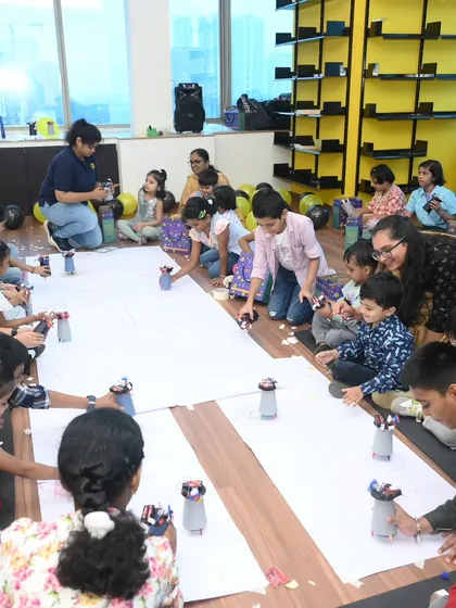 A room full of focused, happy inventors. We set up fully managed activity zones where dozens of children can simultaneously build their own robots, ensuring every child is engaged and has a personal creation to take home.