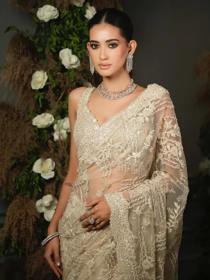 This full-length shot shows the graceful fall of the embroidered net saree by Nitika Gujral, a perfect choice for a reception or engagement.