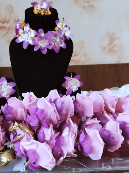 A beautiful set of artificial floral jewellery in shades of purple and pink. This includes a choker, earrings, and kaleeras for the bride.