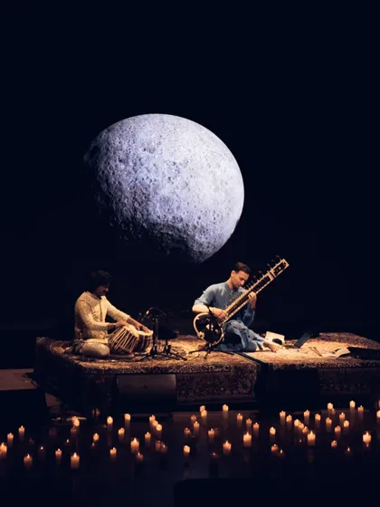 A moment of connection during a 'Sitar for Mental Health' performance in Bangalore. My shows are designed as immersive experiences, using visuals like this moon projection and candlelit stages to create a serene, meditative atmosphere perfect for wellness events and intimate gatherings.