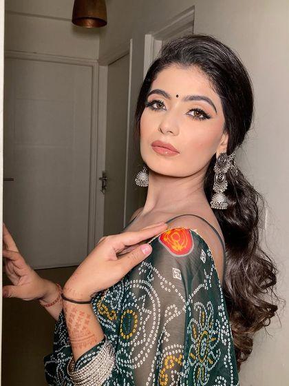 This pose shows off the complete look with the silver jewelry and the elegant saree. A perfect inspiration for wedding guests.