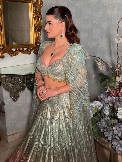 The full cocktail look. The mint green lehenga and the sparkling makeup create a look that is fresh, modern, and glamorous.