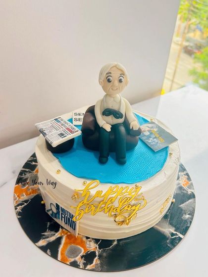 A special cake for Granddad, featuring him relaxing with his newspaper and mutual fund papers.