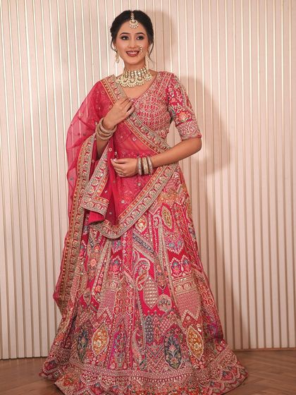 This model showcases a beautiful multi-toned pink and red lehenga, a unique option from my rental collection for those who want a blend of colors.