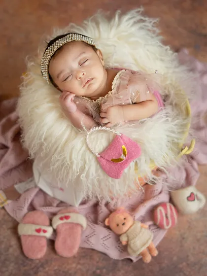 A little fashionista in the making. This setup includes adorable miniature props like slippers, a handbag, and a coffee cup for a fun and stylish newborn shoot.