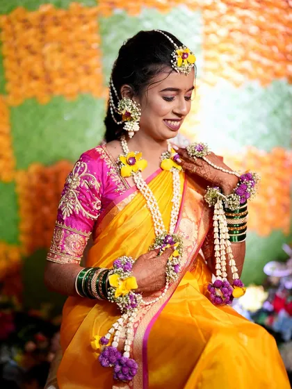 A full view of the Haldi bride's look. The hairstyle and floral jewelry create a fresh, vibrant, and joyful appearance perfect for the occasion.