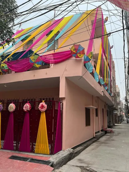 Your wedding celebrations should start from the moment guests arrive. Here, I've decorated the entire exterior of a home with colorful drapes, decorative umbrellas, and floral touches to create a festive welcome for a Mehndi function.