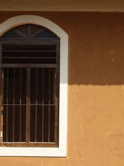The texture of a mud-plastered wall catching the sunlight. The beauty of mud is its simplicity and its ability to blend seamlessly with the natural environment, creating a home that feels like it grew from the earth.