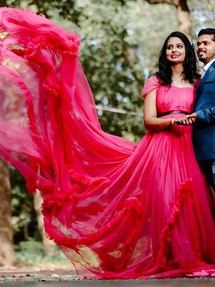 A vibrant pre-wedding shot in a park. The "flying" trail of this magenta ruffled gown creates a stunning visual effect.