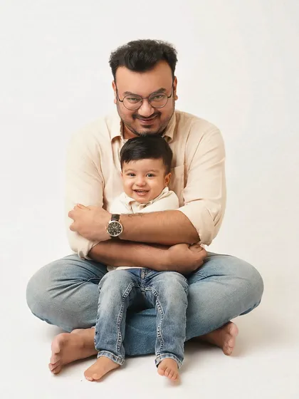A father gives his son a gentle hug from behind. This pose is full of warmth and protection, a beautiful depiction of a father's love.