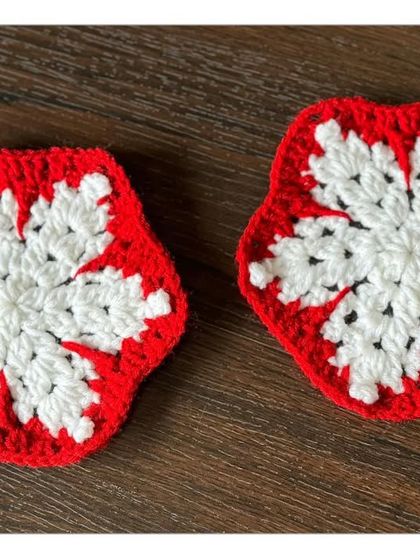 A closer look at the intricate design of my red and white snowflake coasters. The hexagonal shape and detailed pattern make them a lovely handmade accent for your table.