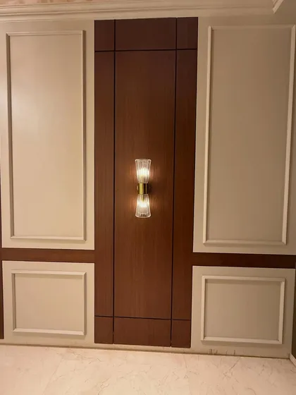 The full view of the entrance wall paneling, combining dark wood tones with classic off-white molding. This creates a timeless and elegant look.