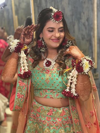 A joyful, candid moment from the Haldi ceremony. The bride's smile and the beautiful details of her floral accessories are the highlight.