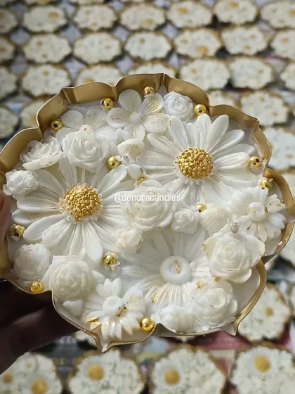 This is one of my signature pieces, a handcrafted lotus urli candle. I meticulously place each floral element into the natural soy wax and finish it with delicate golden details, making it a luxurious centerpiece for any festive occasion.
