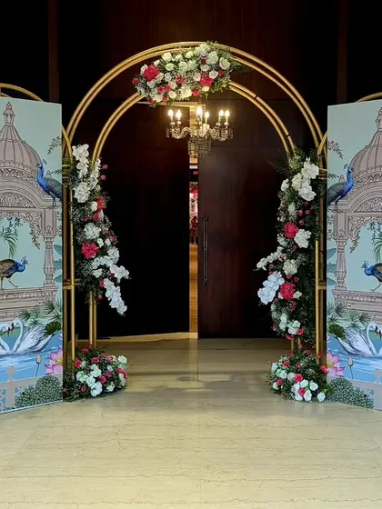 To bring a touch of traditional art to the entrance, I designed these custom panels with peacock motifs, framed by a modern gold arch and fresh flowers, blending heritage with contemporary style.