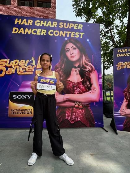 One of our talented students proudly displaying her audition number at the 'Har Ghar Super Dancer Contest'. We prepare each dancer with custom choreography to help them shine.