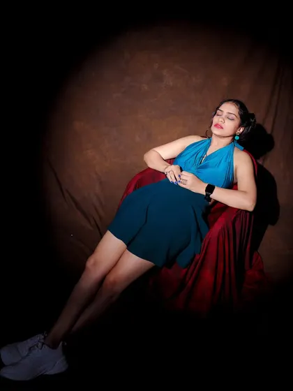 A dramatic spotlight shot. The model is relaxing in a chair, creating a moody and cinematic feel for a portfolio.