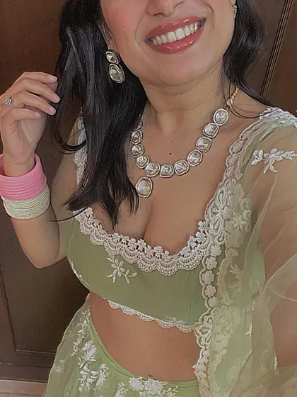 A close-up of a delicate pastel green lehenga, perfect for a sister of the bride or groom. The look is styled with a simple kundan necklace and a contrasting pink choora.