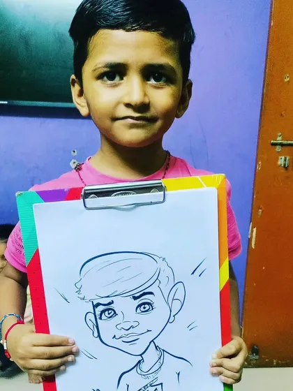 A close-up of a young boy proudly holding his caricature. I focus on capturing their happy expressions and unique features in my drawings.