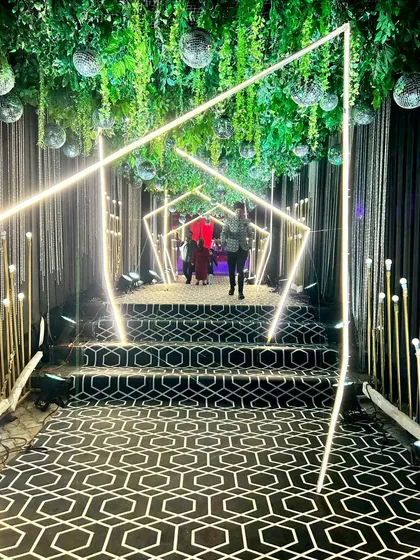The full view of the Sangeet entrance tunnel, a perfect example of how we use lighting and structure to build excitement.