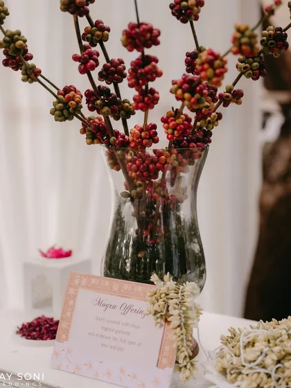 A unique floral arrangement using coffee cherry branches, adding an unexpected and rustic element to the decor.