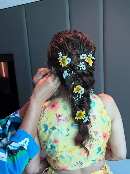 Another angle of the floral messy braid, showing the intricate detail and the beautiful combination of yellow and white flowers.