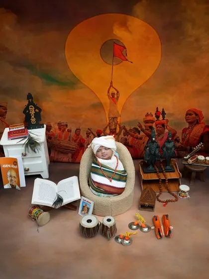 A complete Pandharpur Wari scene for a newborn. This elaborate setup features a backdrop of the wari, miniature idols, and traditional instruments, creating a soulful portrait of a tiny devotee.