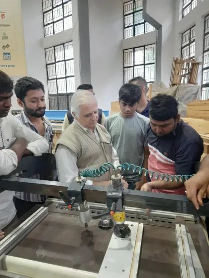 A group of students gathers around a machine as our senior instructor explains its function and demonstrates a specific technique.