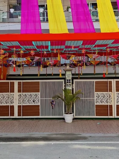 A straight-on shot of the decorated entrance gate. The combination of the overhead tent and the bright colors makes the house stand out for the special occasion.