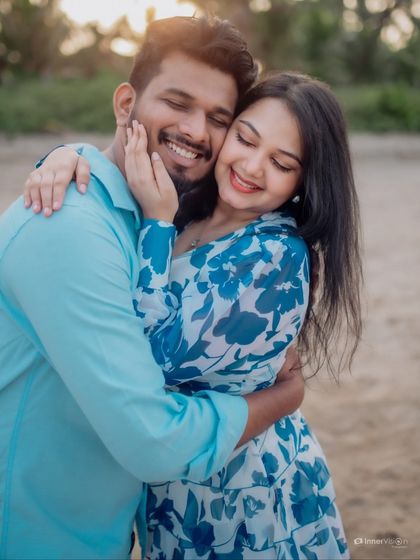 A hug filled with warmth and genuine smiles. This candid portrait from a beach session showcases the couple's easy comfort and happiness with each other.