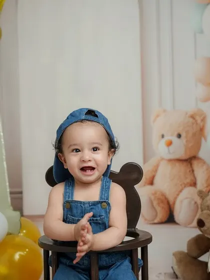 Clapping with excitement for his big day. This shot captures the pure joy and energy of a first birthday celebration in the studio.