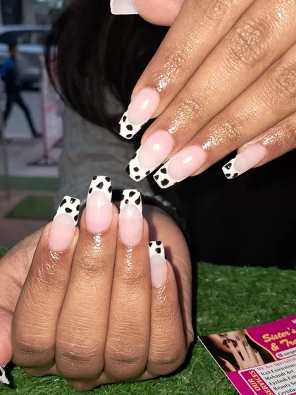 Another view of the fun and trendy cow print French manicure on long coffin nails.