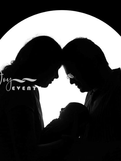 A powerful and intimate family portrait. This silhouette shot captures the parents tenderly looking at their newborn baby, creating a timeless and artistic image that focuses on the emotional connection of a new family.