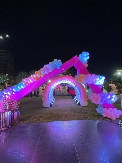 The entrance to a princess party, featuring a house-shaped arch and a rainbow balloon tunnel, creating a fairytale welcome.