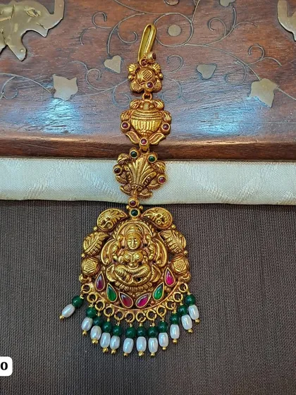 This traditional maang tikka is crafted from hallmarked 92.5 silver and plated in gold for a rich, authentic look. The centerpiece features a beautifully detailed Goddess Lakshmi motif, perfect for bridal and temple jewelry collections.