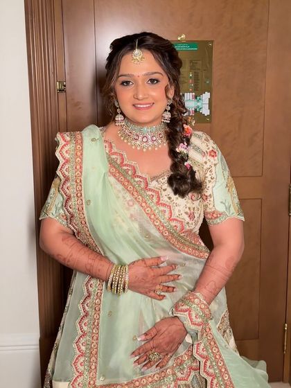 The bride looking radiant and happy in her pastel green wedding lehenga. The makeup is soft and glowing, with a focus on her beautiful eyes.