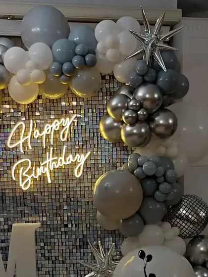 A grey and silver sequin backdrop with a matching balloon garland, offering a sleek and modern look for any celebration.