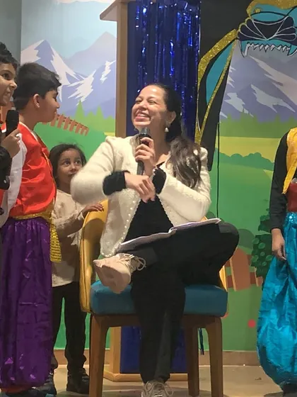An instructor shares a laugh with the young cast members. I guide the children through every step of the production, from learning lines to stage presence, in a fun and supportive way.