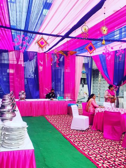 The interior of the Mehendi night tent, showing the catering setup and guest tables under a canopy of blue and pink drapes.
