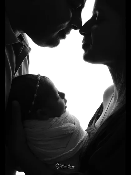 This silhouette captures the parents' profiles as they look at their baby, creating a frame around the newest family member.