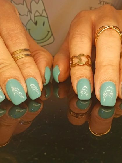 A full view of the charming teal and daisy nail art.