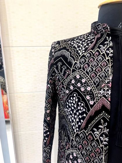 A side view of the black patterned Indo-Western jacket, highlighting the detailed embroidery that runs along the sleeve and body.