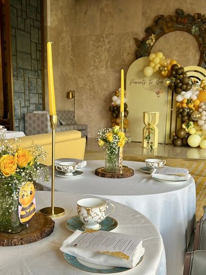 Elegant table settings for the 'Mommy to Bee' themed baby shower. We used fine china, yellow taper candles, and fresh yellow roses to create a sophisticated high-tea experience.