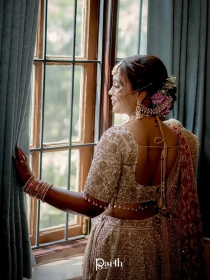 A view from the back, showing the lovely floral bun and the backless design of her blouse.