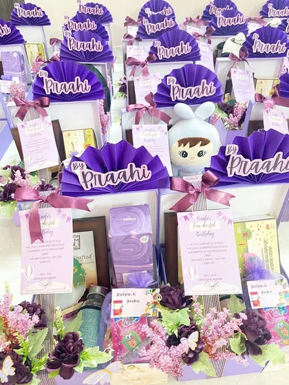 A whole collection of thank you gifts for Praahi's first birthday party guests. Each hamper includes a personalized card, a soft toy, and other treats.
