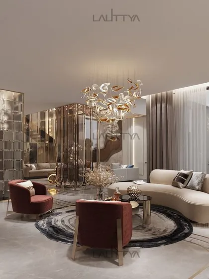 This living room design blends comfort and elegance, with a curved sofa, deep red armchairs, and a sculptural floor lamp. The space is unified by a neutral color palette with pops of color and metallic accents.