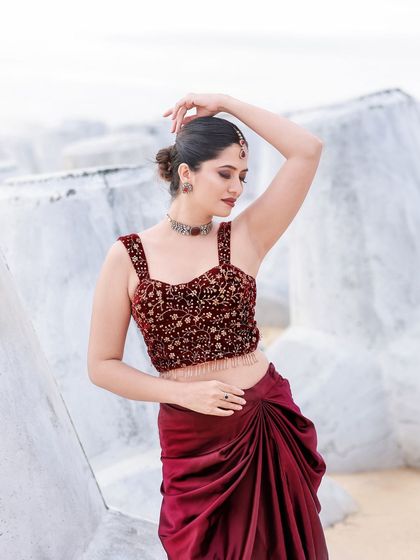 A beachside fashion shoot for a designer's modern-ethnic collection. The models are posed against the sea and coastal rocks to create a windswept, editorial feel that highlights the clothing.