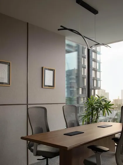 For a modern finance startup, we designed a conference room that balances professionalism with a connection to the urban landscape. Floor-to-ceiling windows offer expansive city views, while sound-absorbing wall panels and an elegant, minimalist light fixture ensure a functional and sophisticated meeting environment.